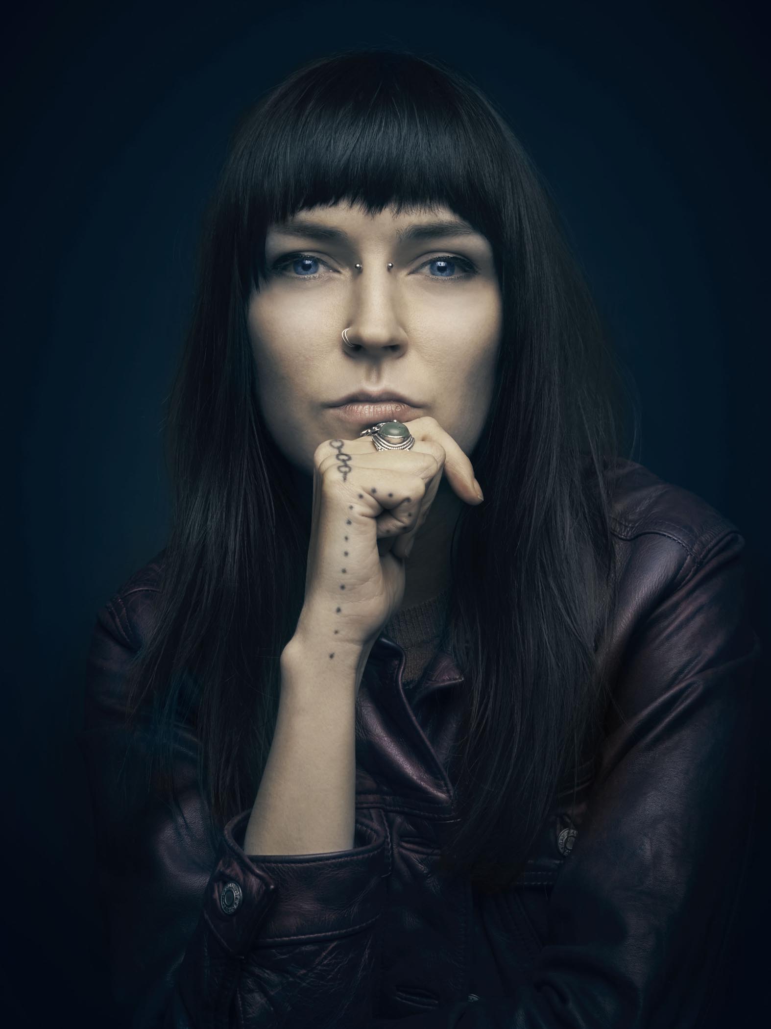 Portrait of a woman wearing leather with hand on chin