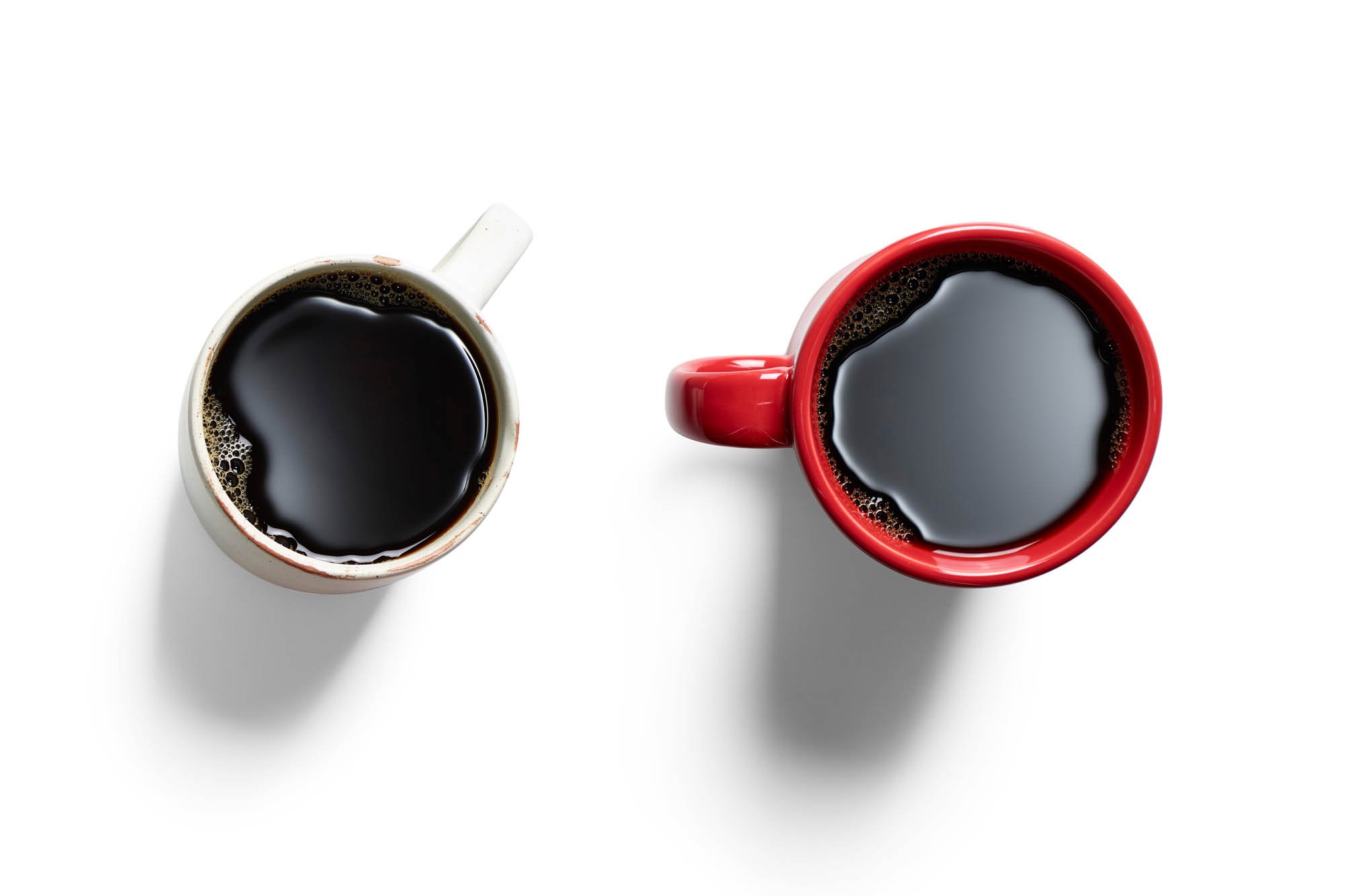 Two cups of black coffee overhead. Red cup and white cup