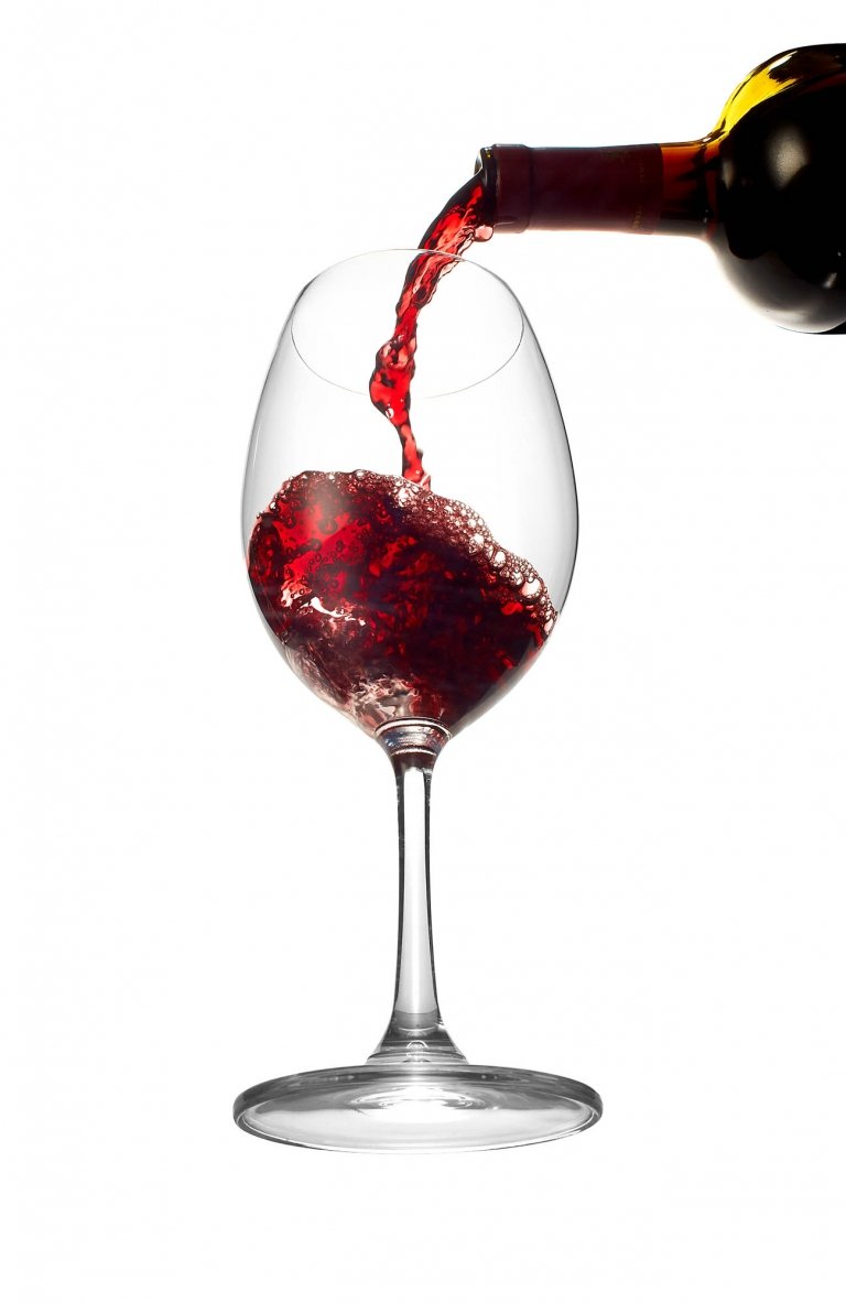 A glass of wine pouring into a glass - drink photography